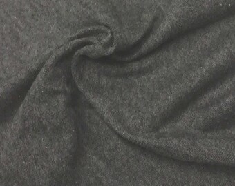 Puede incluir: Primer plano de una tela gris oscuro con una superficie texturizada. La tela es suave y tiene un aspecto ligeramente peludo.