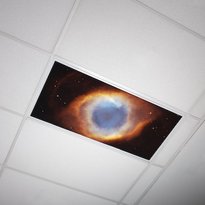 May include: A white ceiling with a square panel featuring a colorful nebula image. The nebula is a swirling mix of orange, yellow, and blue with a dark center.