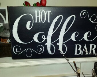 Könnte beinhalten: Schwarzes Holzschild mit weißer, kursiv geschriebener Aufschrift "Hot Coffee Bar".