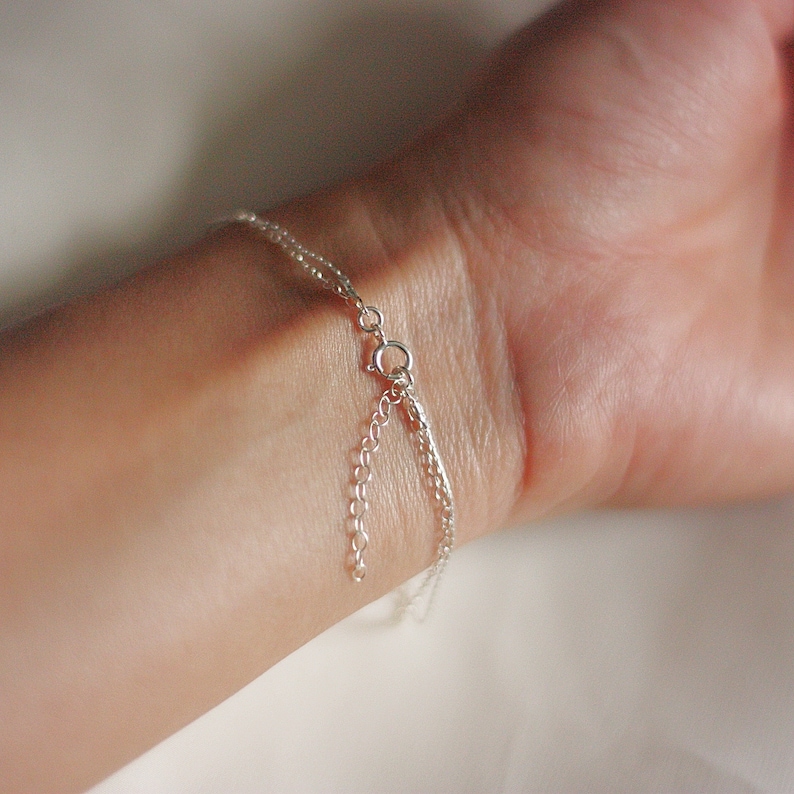 May include: A silver chain bracelet with a lobster clasp closure.