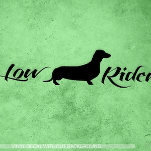 May include: Black silhouette of a dachshund with the text "Low Rider" in a stylised font.