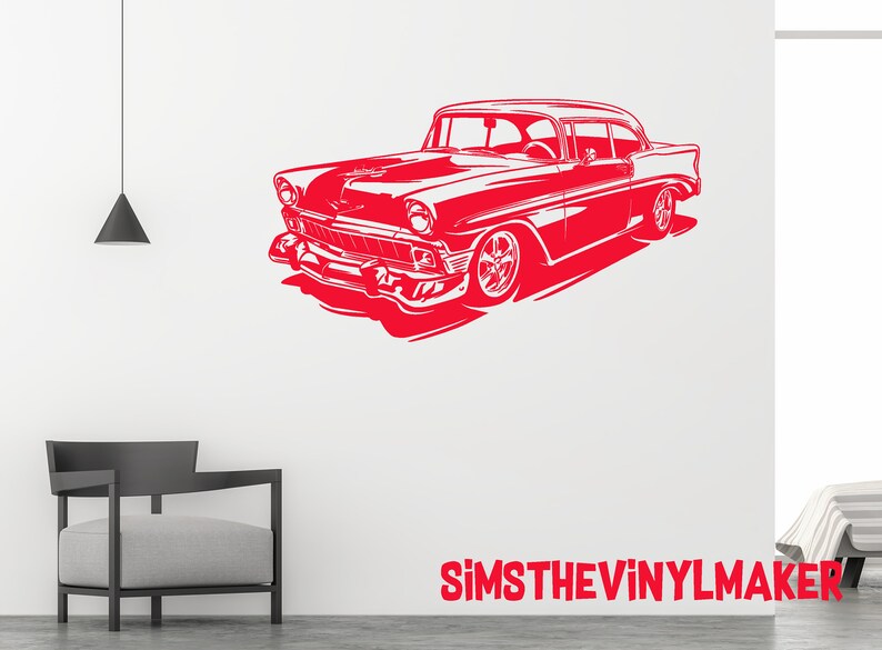 May include: Red silhouette of a classic car on a white background. The car has a rounded body style and large, round headlights. The image is a simple, stylized design.