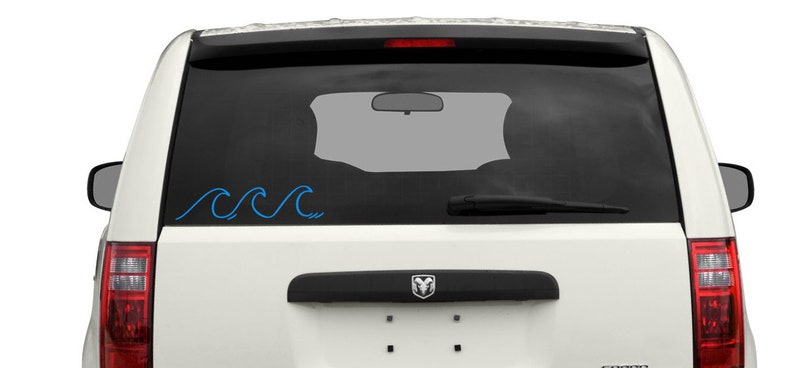 K&ouml;nnte beinhalten: Ein wei&szlig;er SUV mit einem blauen Wellensticker an der Heckscheibe.