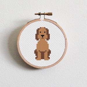 May include: A brown dog cross stitch pattern in a wooden embroidery hoop.