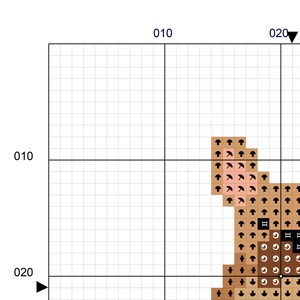 May include: A cross-stitch pattern featuring a brown bear with a pink nose and black eyes. The bear is sitting on a brown background with a white outline.