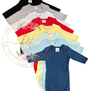 May include: A collection of long-sleeved baby gowns in various solid colors including black, gray, white, red, yellow, light green, light blue, and dark blue, each featuring a round neckline and a cinched bottom hem for easy access.