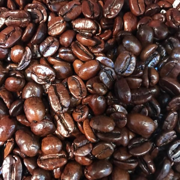May include: A close-up image of a large pile of dark brown coffee beans.