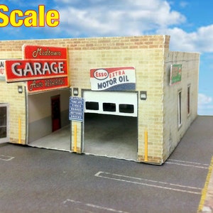 May include: A model of a brick garage with a sign that reads "Midtown Garage Auto Repairing". The garage has a large overhead door and a smaller door on the side. There is a sign on the side of the garage that reads "Esso Extra Motor Oil".