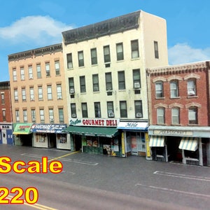 Peut inclure: Mod&egrave;le d'une rue de ville avec cinq b&acirc;timents en briques, chacun avec une vitrine. Les vitrines ont des auvents et des enseignes, dont "Gourmet Deli", "Hardware", "Bar", "Grocery" et "Glasscraft". Les b&acirc;timents sont &agrave; l'&eacute;chelle Z, soit 1:220.