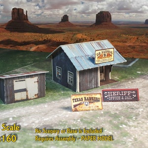Puede incluir: Un kit de maquetas de papel de un edificio de estilo occidental con un letrero que dice "U.S. Marshal" y otro letrero que dice "Sheriff's Office & Jail". El modelo est&aacute; en escala N, que es 1:160.