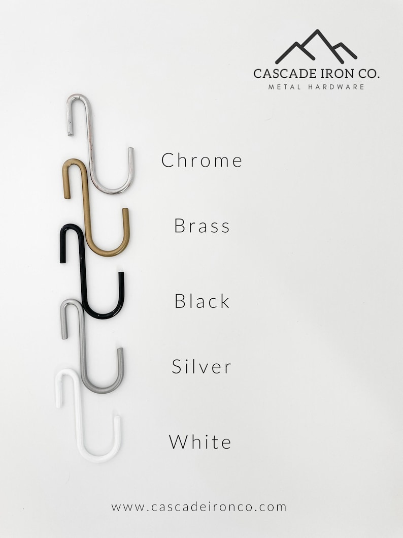 Five S-shaped hooks in different finishes: chrome, brass, black, silver, and white.  The hooks are displayed against a white background with the text "CASCADE IRON CO. METAL HARDWARE" and "www.cascadeironco.com".
