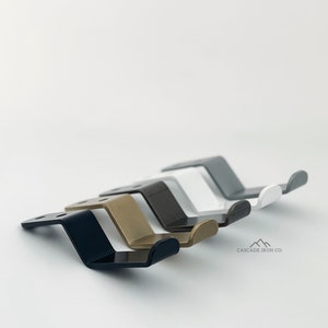 May include: A set of three ceramic mugs with a speckled, matte finish. The mugs are in shades of cream, light gray, and dark gray. Each mug has a simple, minimalist design, perfect for coffee or tea.