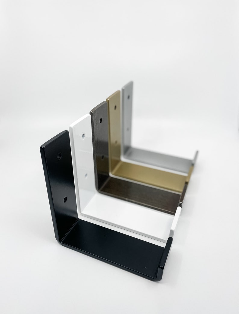 Five heavy duty metal J style hook brackets lined up in different powder coated finishes: black, white, raw steel, brass, silver
