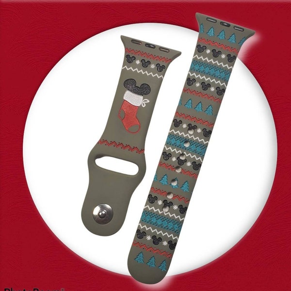 以下が含まれることがあります： クリスマスをテーマにしたデザインの緑色のApple Watchバンド。靴下、雪片、ミッキーマウスの頭が描かれています。バンドはシリコン製で、安全な留め具が付いています。
