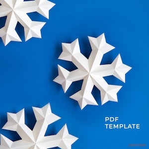 Könnte beinhalten: Drei weiße Papierschneeflocken auf blauem Hintergrund. Die Schneeflocken sind alle unterschiedlich groß und haben einen 3D-Effekt. Der Text "PDF TEMPLATE" befindet sich am unteren Rand des Bildes.