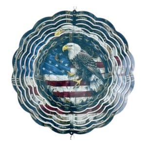 May include: A metal wind spinner with a layered design featuring an American bald eagle perched on an American flag. The flag is distressed and has a rope border. The wind spinner is circular and has a silver finish.