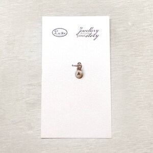 May include: A silver charm with the letter A on a white card with the text "Jewellery that tells your story" and the logo "Luxe Design".
