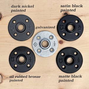 May include: Five circular metal floor flanges with four screw holes and a central threaded opening marked 1/2 inch. The finishes include dark nickel, satin black, galvanized silver, oil rubbed bronze, and matte black paint, each labeled accordingly.