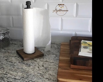 May include: A paper towel holder featuring a square dark wood base and a black metal pipe vertical rod with a matching black cap. A roll of white paper towels is mounted on the rod. The logo Lightrooom Shop is visible in the background.