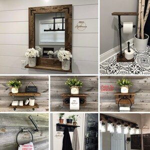 May include: A collection of bathroom fixtures featuring dark stained wood shelves and black industrial pipe hardware, including a mirror with a shelf, a toilet paper stand, wall-mounted towel rings, a coat rack, and a vanity light fixture with glass shades.