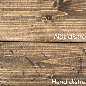 May include: Close-up of two wooden planks with a brown stain. The top plank is labeled "Not distressed," while the bottom plank is labeled "Hand distressed," showcasing the difference in texture and appearance.