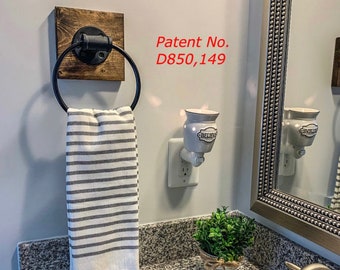May include: A wall-mounted towel ring featuring a black metal circular holder attached to a square dark wood base. A white and gray striped hand towel hangs from the ring. The text Patent No. D850,149 is visible on the wall near the towel ring.