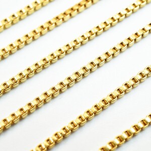 Puede incluir: Cuatro hebras de cadena de oro, cada una con un patr&oacute;n de cadena de caja, se colocan sobre una superficie blanca.