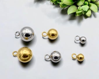 May include: An assortment of metallic ball charms in gold and silver. Each charm has a small loop attached for easy attachment to jewelry or other crafts. The charms vary in size and are displayed against a neutral background.
