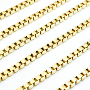 A close-up view of several gold-colored metal chains arranged in a repeating pattern.