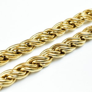 May include: A close-up of a gold rope chain necklace. The chain is made of thick, twisted links and has a shiny finish.