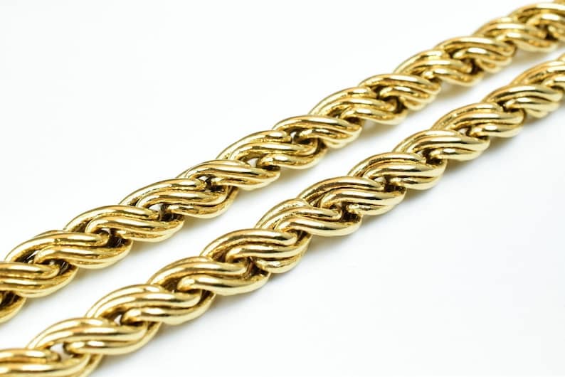 May include: A close-up of a gold rope chain necklace. The chain is made of thick, twisted links and has a shiny finish.