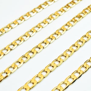 May include: Gold-colored curb chain necklaces arranged diagonally against a white background. The chains have a classic, interlocking link design, and the gold finish gives them a bright, polished appearance. The chains are likely jewelry.