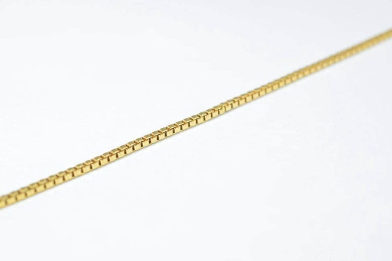 A gold chain necklace is shown against a white background.