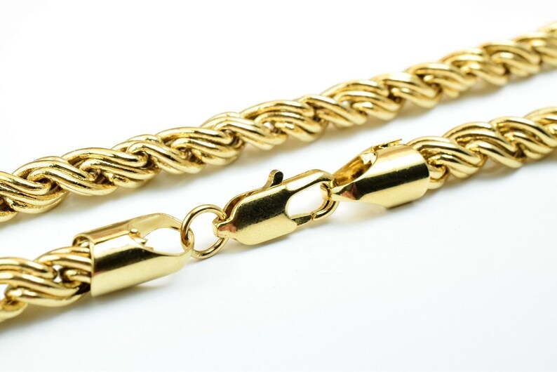 May include: A gold rope chain necklace with a lobster clasp closure.
