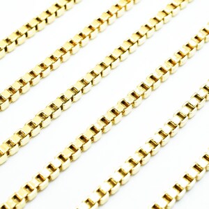 A close-up image of several gold-colored metal chains arranged in a diagonal line.