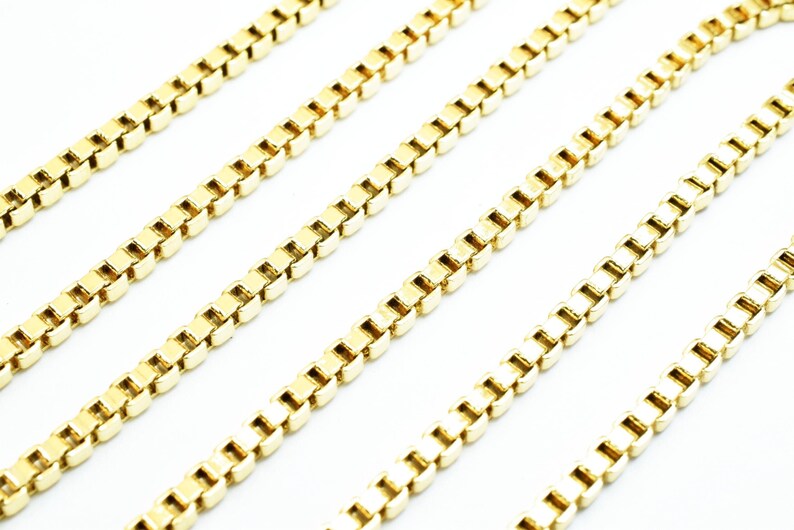 A close-up image of several gold-colored metal chains arranged in a diagonal line.