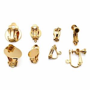 Könnte beinhalten: Eine Sammlung goldfarbener Ohrclip-Verschlüsse in verschiedenen Ausführungen. Die Verschlüsse umfassen runde, ovale und verstellbare Designs, alle mit glänzendem, metallischem Finish. Diese Komponenten sind für die Schmuckherstellung.