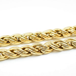 May include: A close-up of a gold rope chain necklace. The chain is made of thick, twisted links.