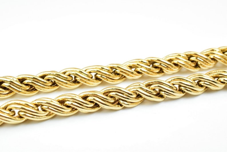 May include: A close-up of a gold rope chain necklace. The chain is made of thick, twisted links.