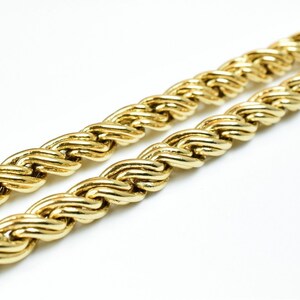 May include: A gold rope chain necklace with a thick, braided design.