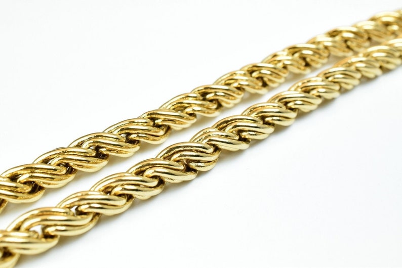 May include: A gold rope chain necklace with a thick, braided design.