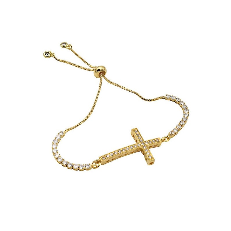 Puede incluir: Un brazalete ajustable de oro con un dije de cruz. La cruz est&aacute; incrustada con piedras de circonita c&uacute;bica transparentes.