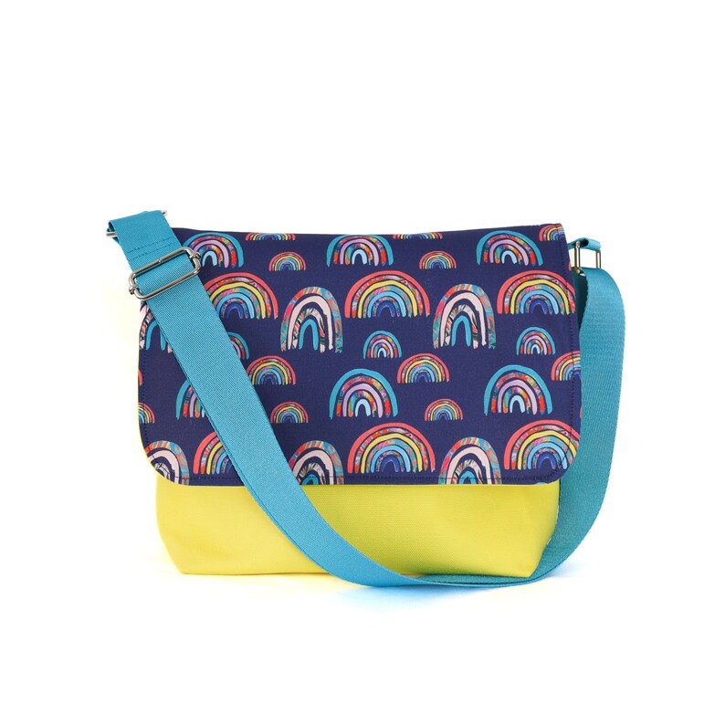 May include: A blue and yellow messenger bag with a rainbow pattern. The bag has a long adjustable strap.