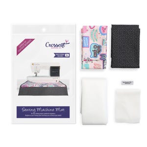 May include: A sewing machine mat kit with a sewing machine, fabric, and other supplies. The kit includes a sewing machine mat with the text "Sewing Machine Mat". The kit also includes fabric with a pink background and a black fabric with white dots.