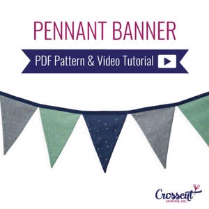 May include: A pennant banner with a PDF pattern and video tutorial. The banner is made of blue, green, and gray fabric with white polka dots. The banner is hanging from a string.