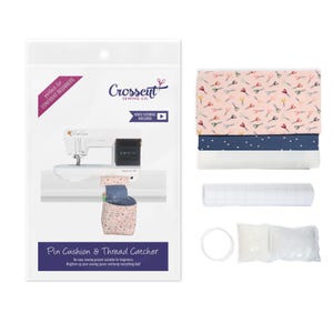 May include: A sewing kit for making a pin cushion and thread catcher. The kit includes fabric, interfacing, a video tutorial, and instructions. The fabric features a pink background with a repeating pattern of colorful scissors.