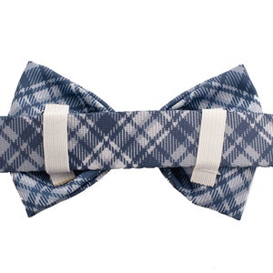 May include: A blue and white plaid bow tie with elastic straps on the back.