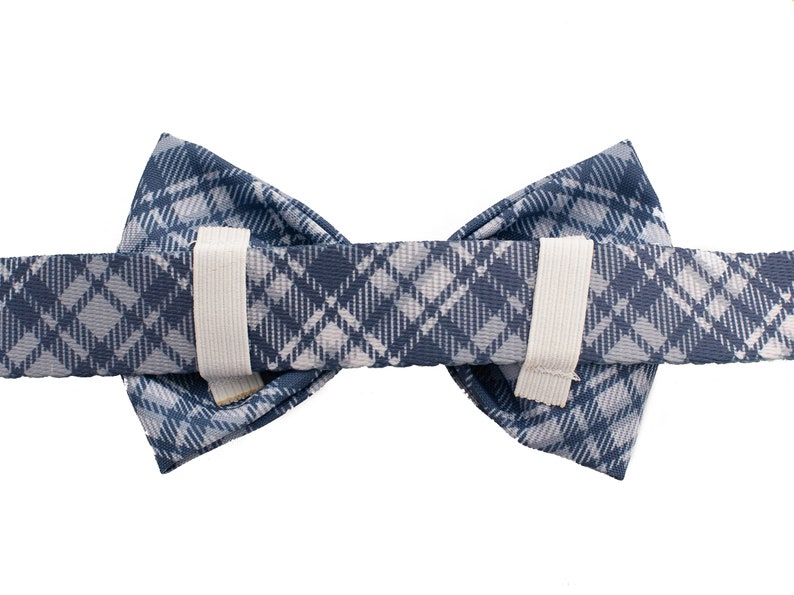 May include: A blue and white plaid bow tie with elastic straps on the back.