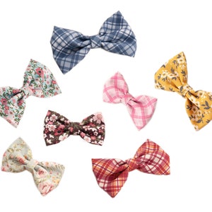 May include: Seven different bow ties in various patterns and colors. The bow ties are made of fabric and have a bow shape. The bow ties are arranged in a circle on a white background.