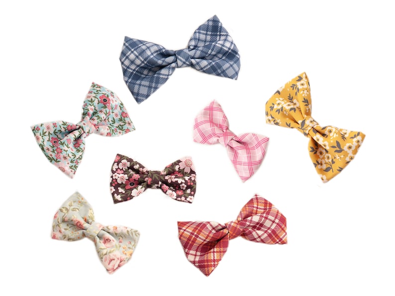 May include: Seven different bow ties in various patterns and colors. The bow ties are made of fabric and have a bow shape. The bow ties are arranged in a circle on a white background.